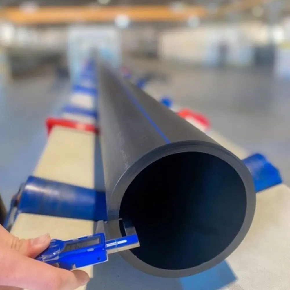 A black HDPE pipe with blue stripes in a factory