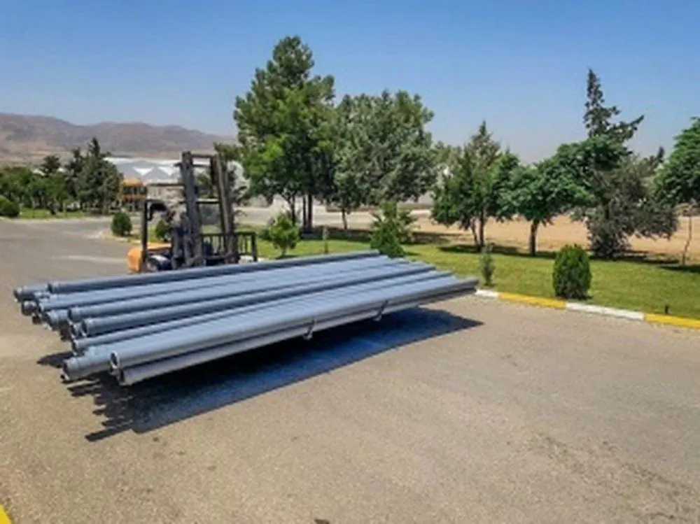 A bundle of grey UPVC pipes beside a forklift
